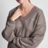Sweter z dekoltem w serek i metalicznym logo