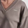 Sweter z dekoltem w serek i metalicznym logo